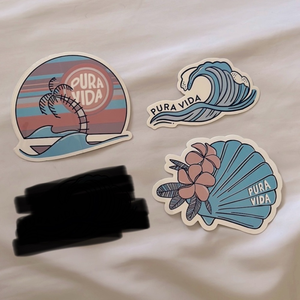 Three stickers from Pura Vida (beach, waves, and seashell).